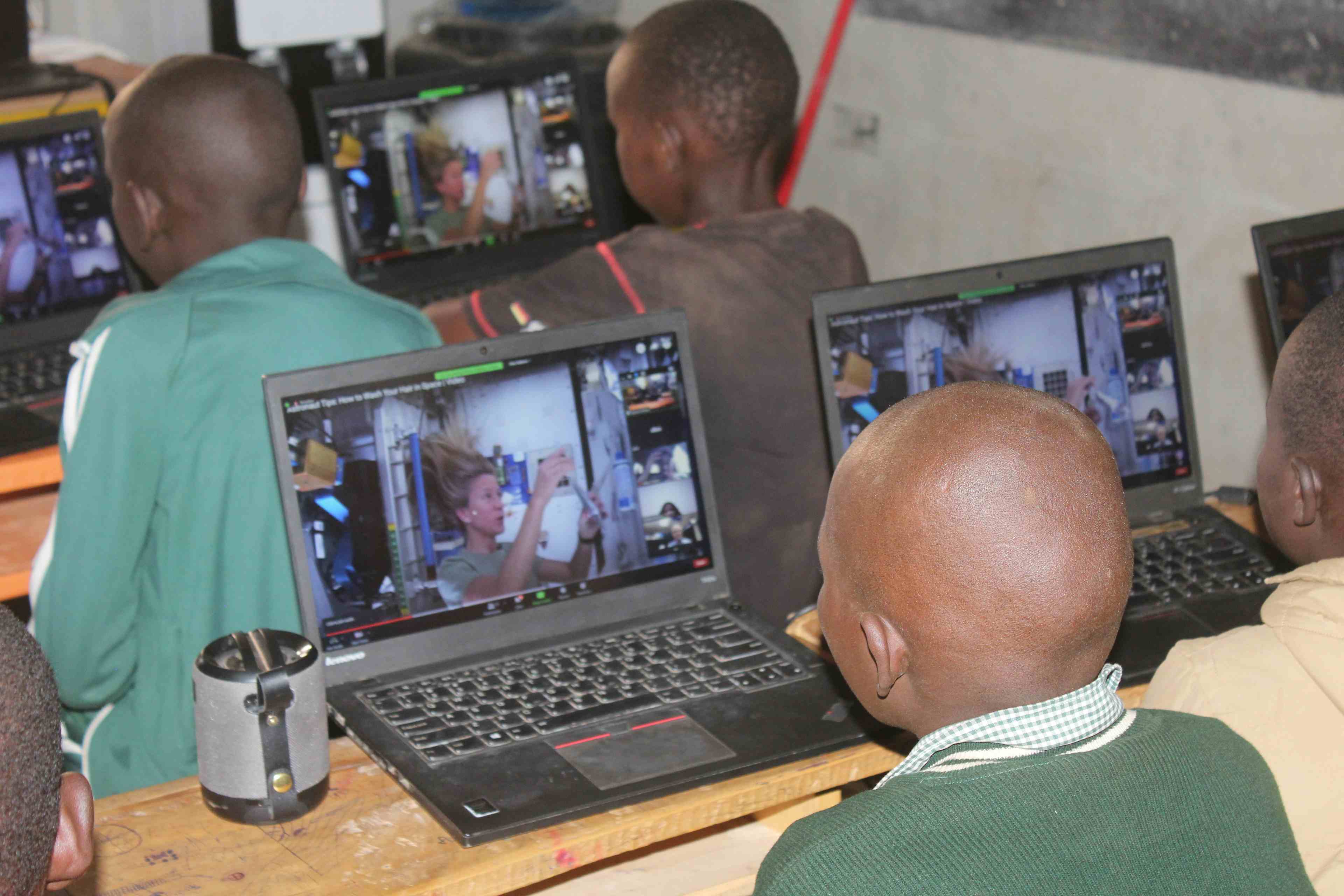 TechLit Students from Zawadi Yetu watching a video on how someones washes their hair in space